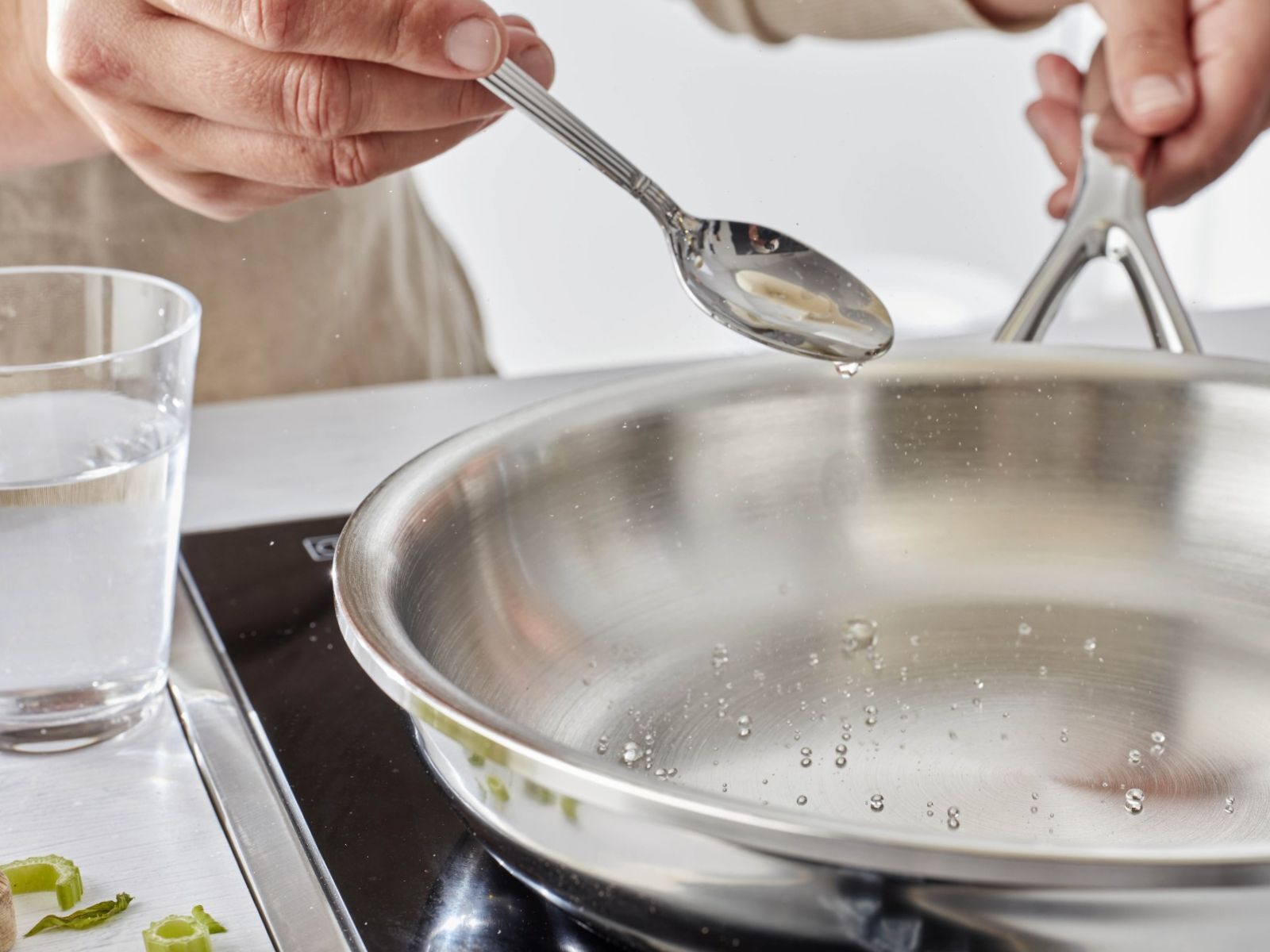 Waterdruppels die tijdens de druppeltest over een roestvrijstalen pan rollen