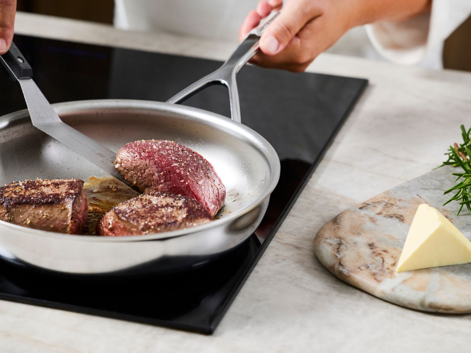 Dikke steak die tijdens het bakken in een pan wordt omgedraaid